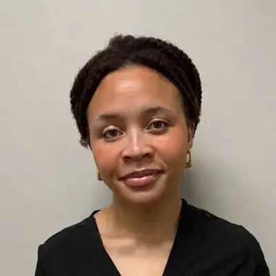 Indira I. smiling at the camera while wearing a black top